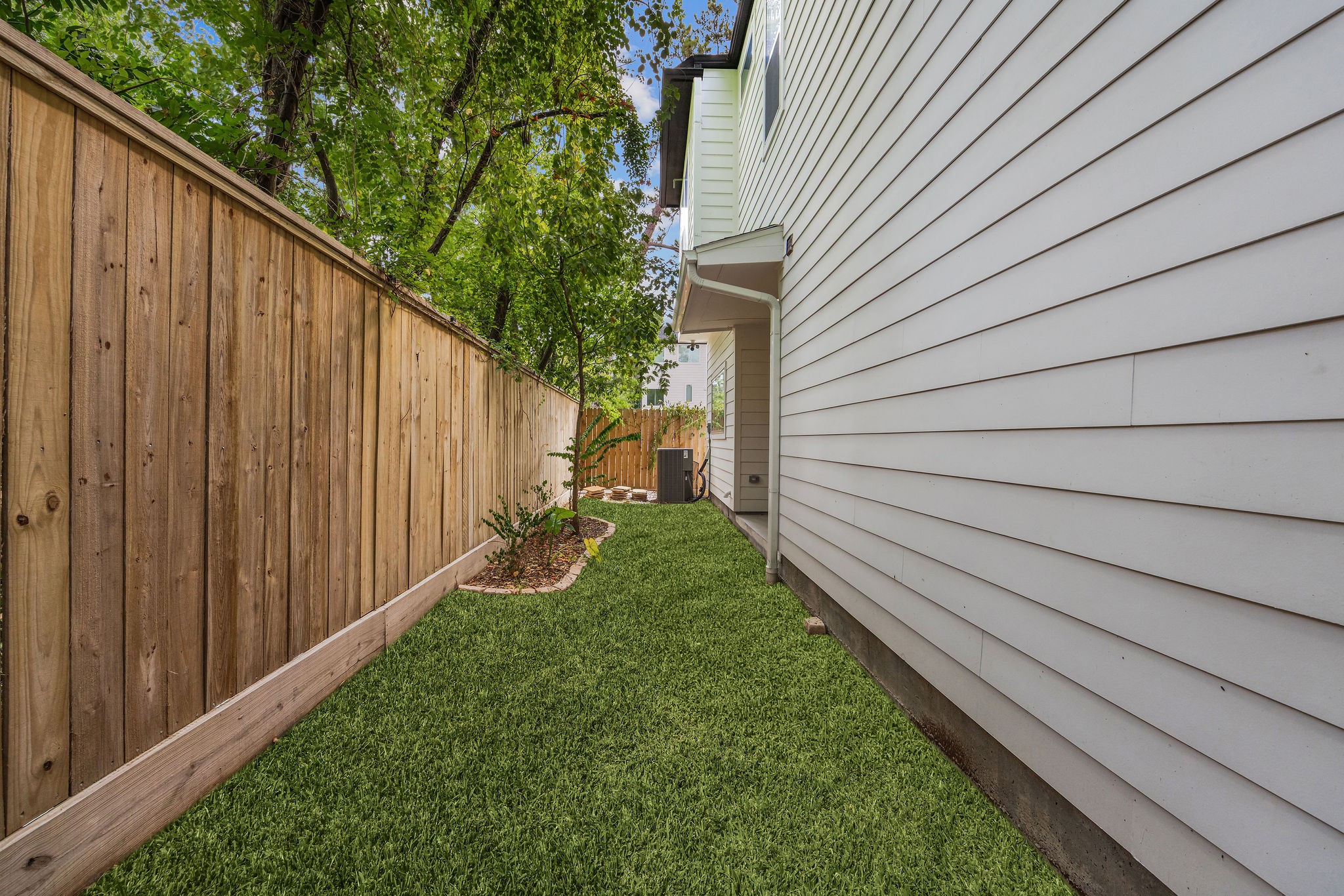 540 Janisch Road, Unit A Houston, TX 77018 - Photo 4 of 18 Spacious fenced side yard surrounded by mature trees, offering additional private outdoor space.