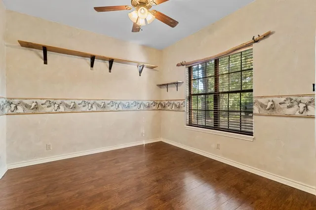 en empty room with windows and ceiling fan
