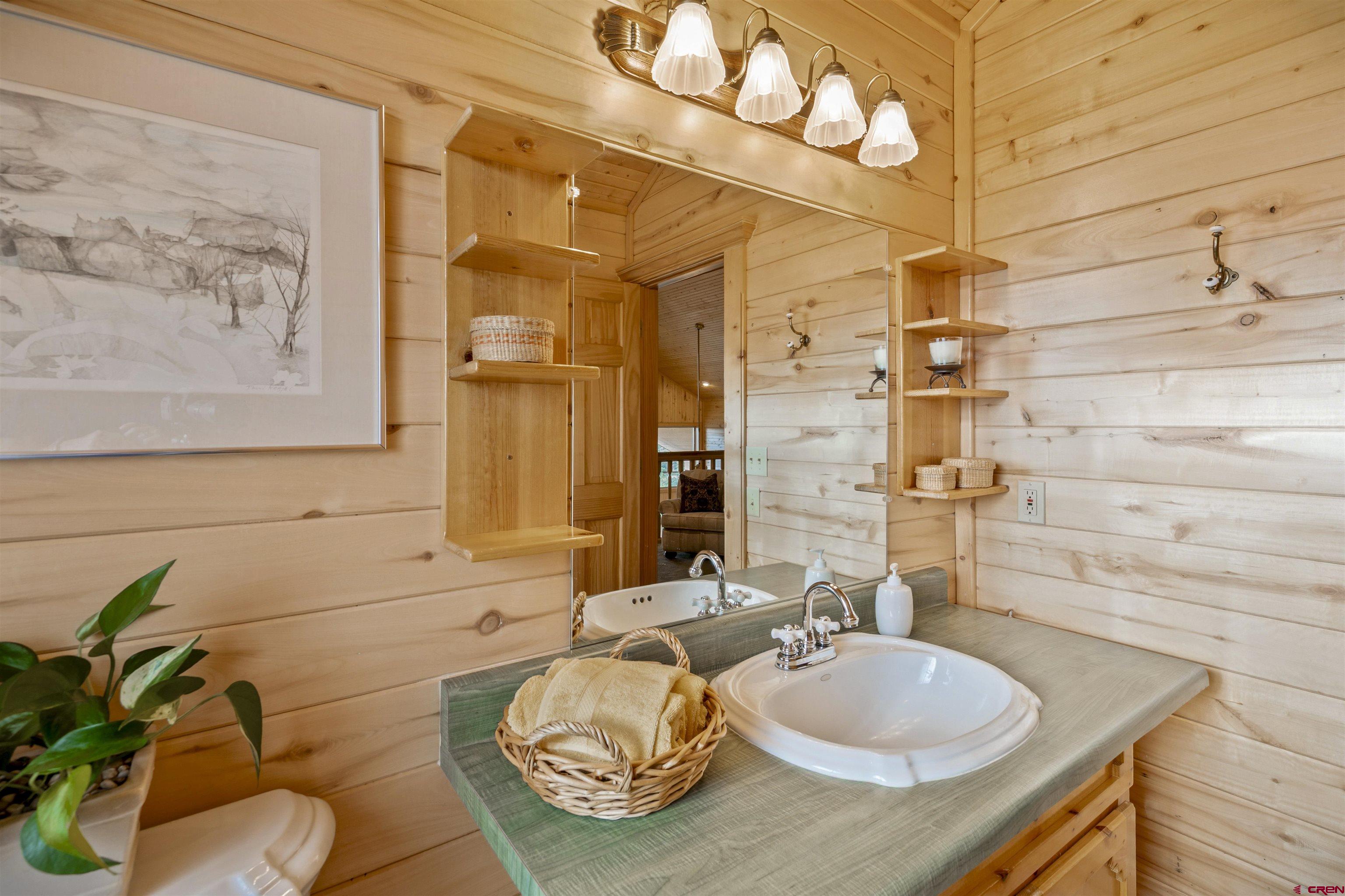 1100 Soaring Eagle Court Chromo, CO 81128 - Photo 25 of 44 a bathroom with a granite countertop sink and a mirror