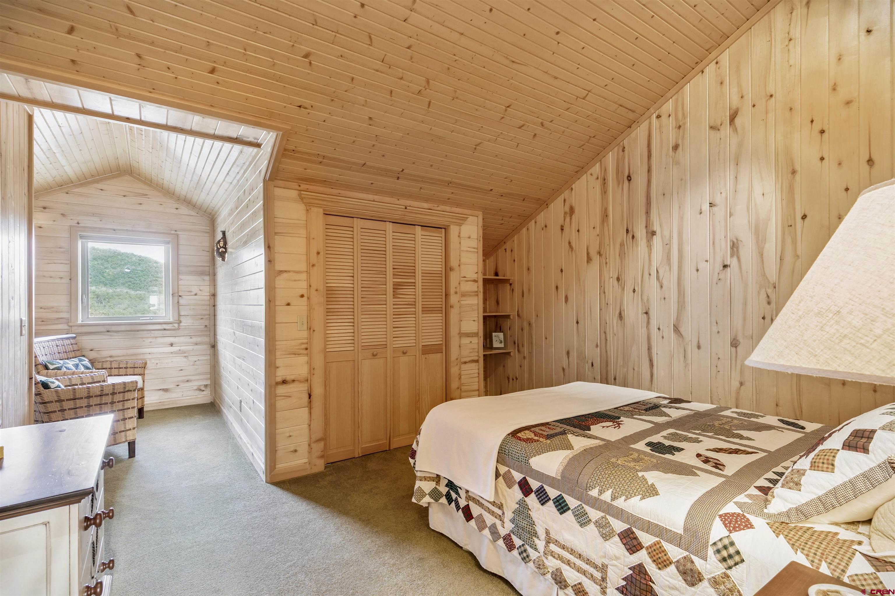 1100 Soaring Eagle Court Chromo, CO 81128 - Photo 27 of 44 a bedroom with a bed and a chandelier