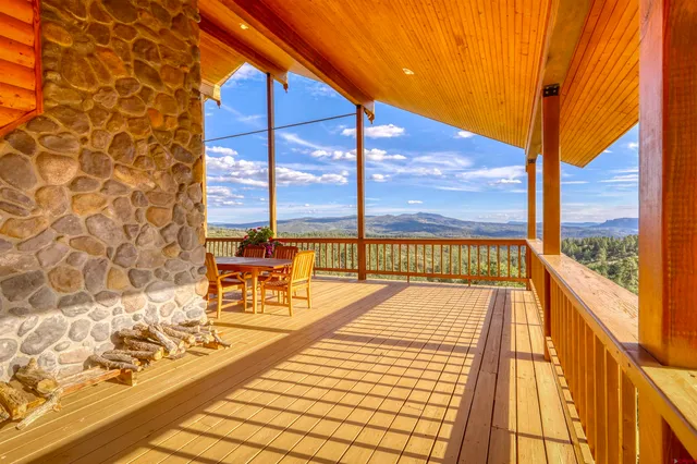 a view of a balcony with wooden floor and a bench