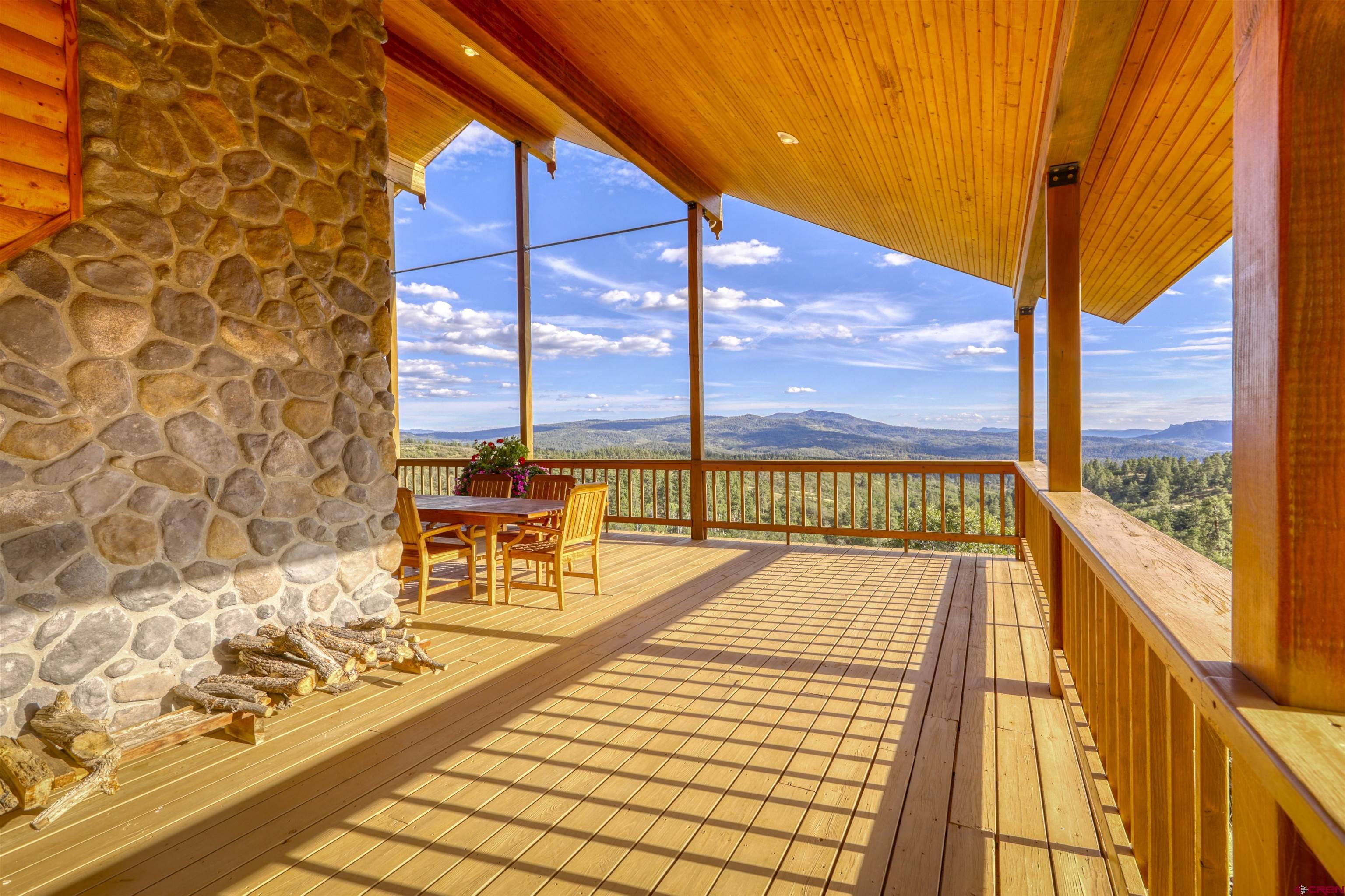 1100 Soaring Eagle Court Chromo, CO 81128 - Photo 3 of 44 a view of a balcony with wooden floor and a bench