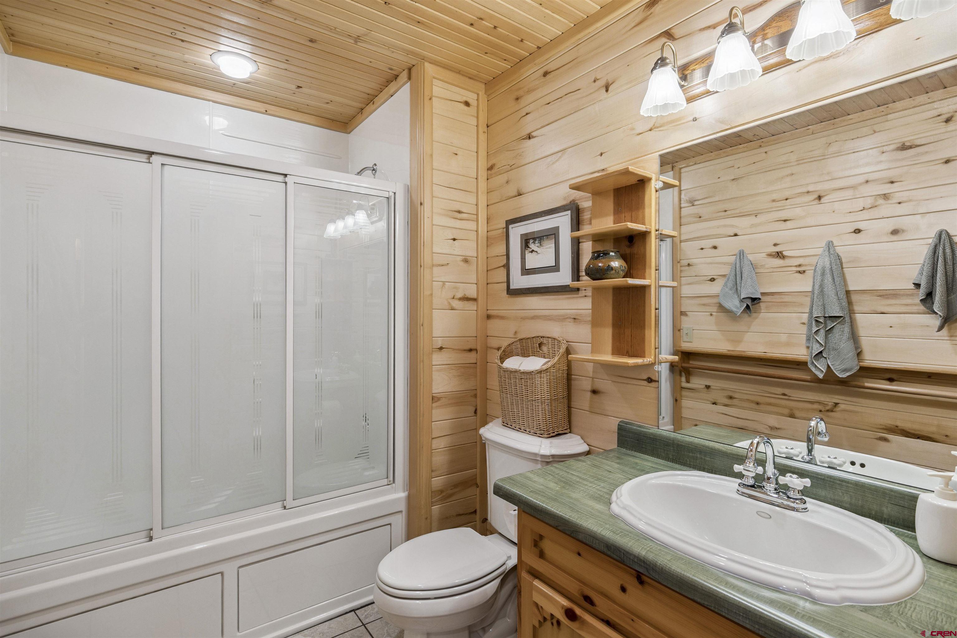 1100 Soaring Eagle Court Chromo, CO 81128 - Photo 37 of 44 a bathroom with a granite countertop sink toilet a mirror a vanity and shower
