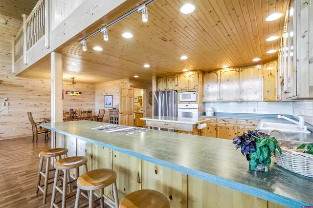 a large dining hall with stainless steel appliances granite countertop a sink and a counter top space