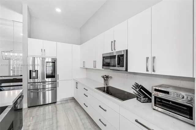a kitchen with stainless steel appliances a refrigerator sink and microwave