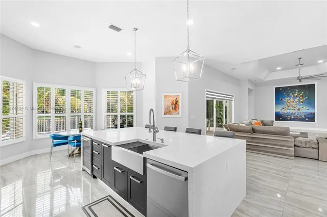 a large kitchen with kitchen island a large island in it