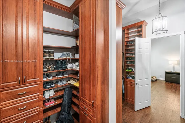 a view of walk in closet with clothes and shoes