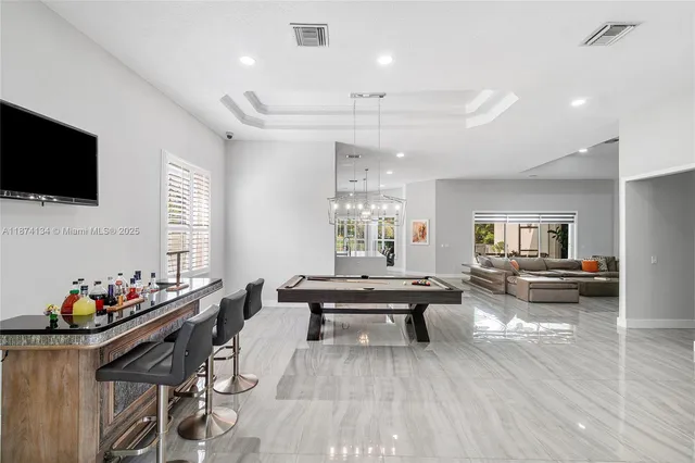 a living room with furniture kitchen view and a flat screen tv