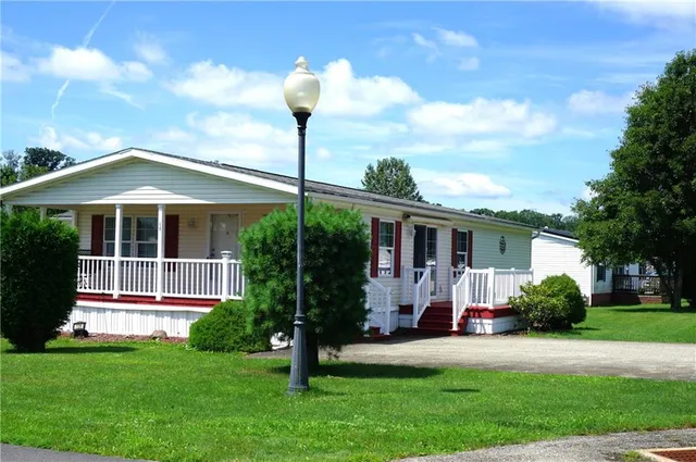 a front view of a house with a garden and plants