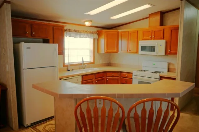 a kitchen with stainless steel appliances a refrigerator a sink a stove and white cabinets