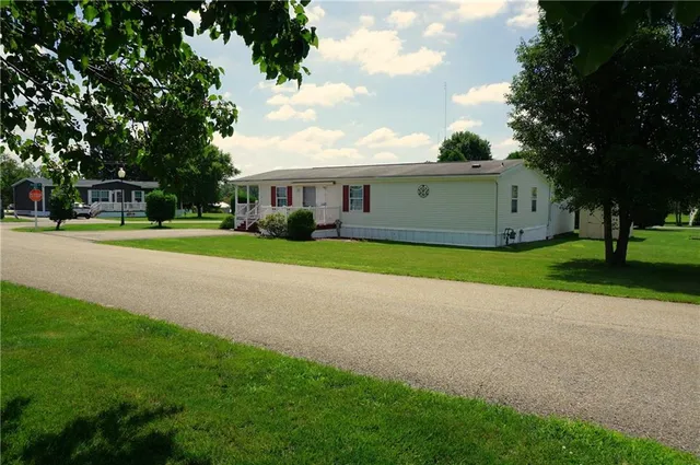 a view of a house with a big yard and large trees