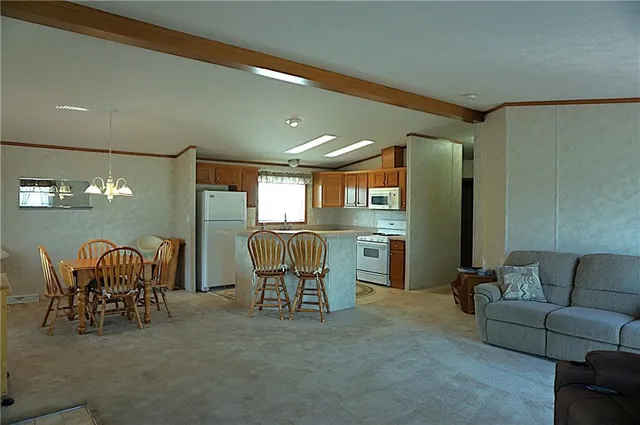 a living room with furniture and a dining table with kitchen view