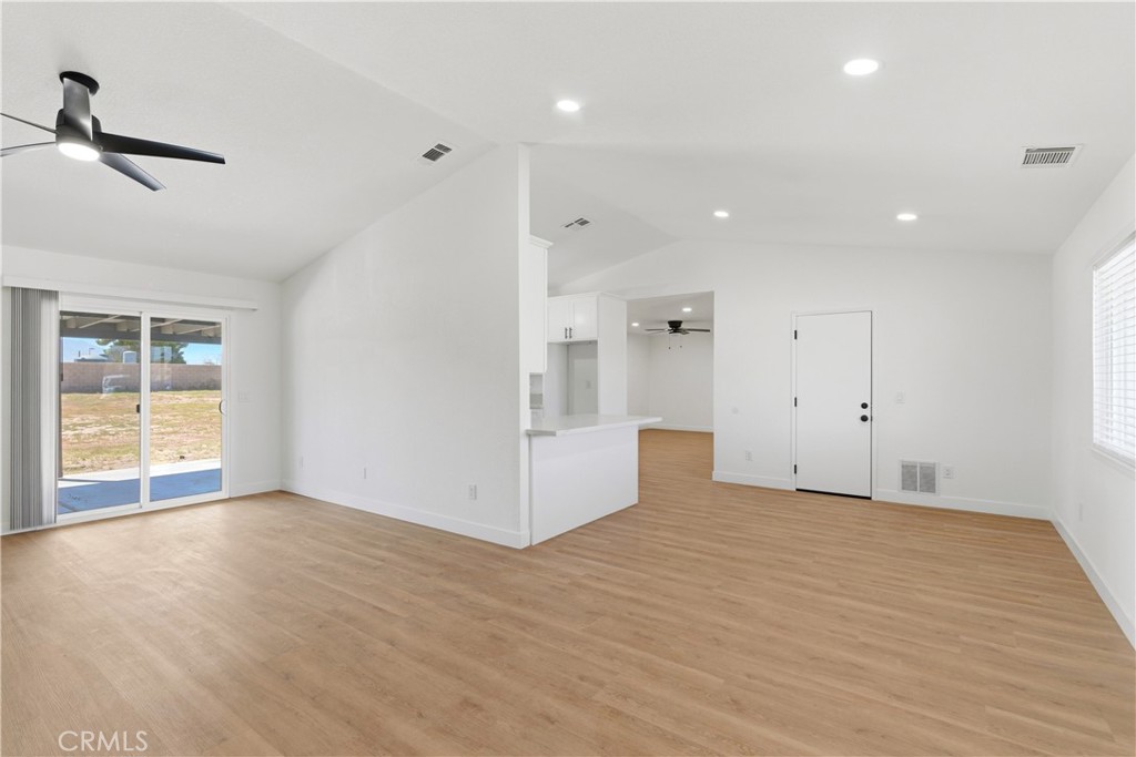 22557 Ojai Road Apple Valley, CA 92308 - Photo 13 of 57 a view of an empty room with wooden floor and a window