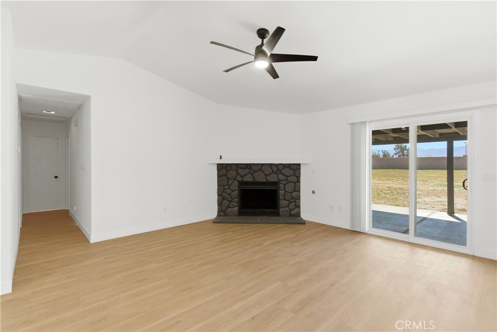 22557 Ojai Road Apple Valley, CA 92308 - Photo 16 of 57 a view of an empty room with a fireplace and a window