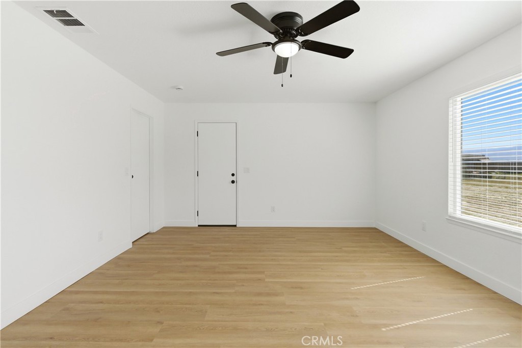 22557 Ojai Road Apple Valley, CA 92308 - Photo 24 of 57 an empty room with a window and a fan