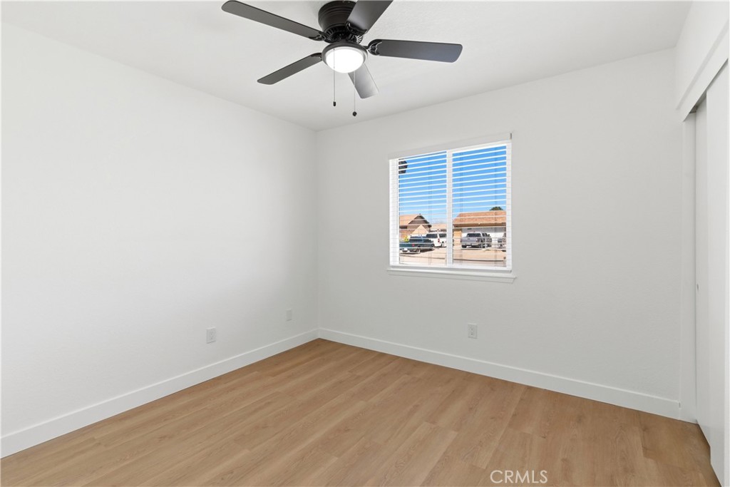 22557 Ojai Road Apple Valley, CA 92308 - Photo 27 of 57 an empty room with a window and a ceiling fan