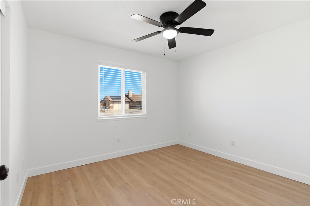 22557 Ojai Road Apple Valley, CA 92308 - Photo 29 of 57 an empty room with a window and a ceiling fan