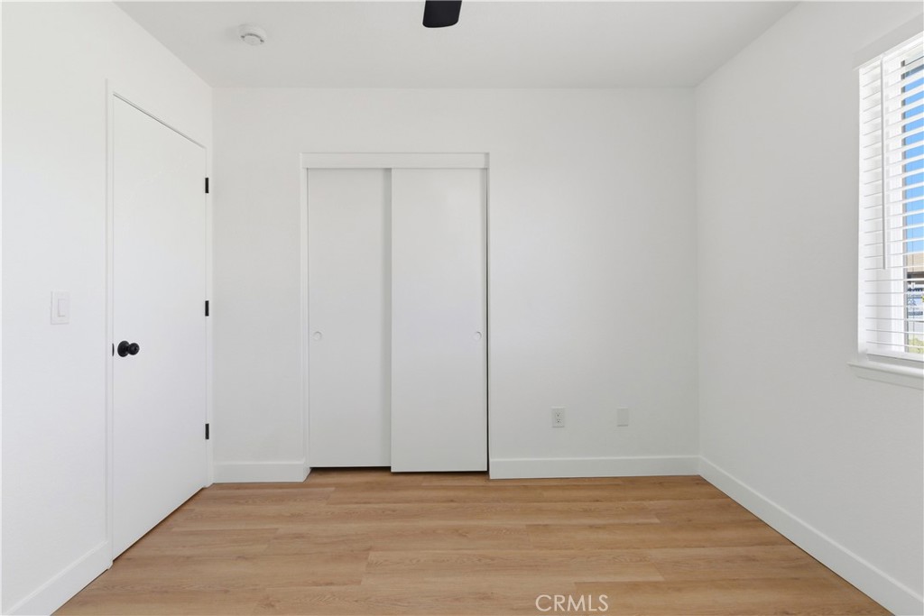 22557 Ojai Road Apple Valley, CA 92308 - Photo 30 of 57 a view of an empty room with wooden floor and a window