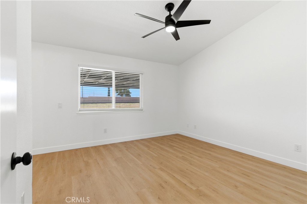 22557 Ojai Road Apple Valley, CA 92308 - Photo 31 of 57 an empty room with a window and a fan