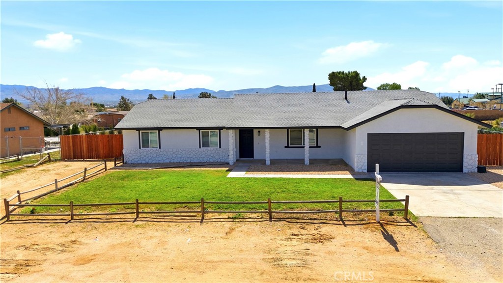 22557 Ojai Road Apple Valley, CA 92308 - Photo 45 of 57 a house with green field in front of it