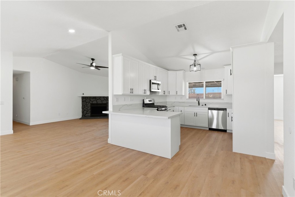 22557 Ojai Road Apple Valley, CA 92308 - Photo 6 of 57 a view of kitchen with stainless steel appliances refrigerator stove microwave and cabinets