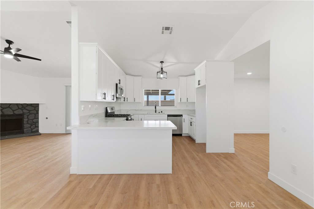 22557 Ojai Road Apple Valley, CA 92308 - Photo 7 of 57 a living room with stainless steel appliances kitchen island hardwood floor and a sink