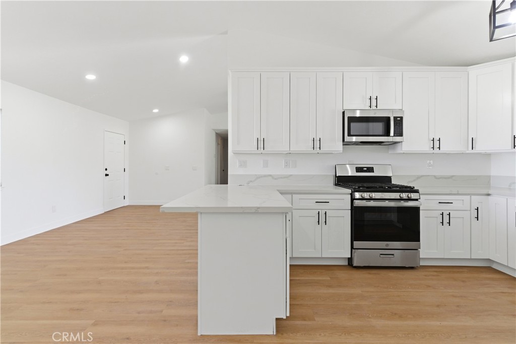 22557 Ojai Road Apple Valley, CA 92308 - Photo 8 of 57 a kitchen with granite countertop white cabinets and stainless steel appliances