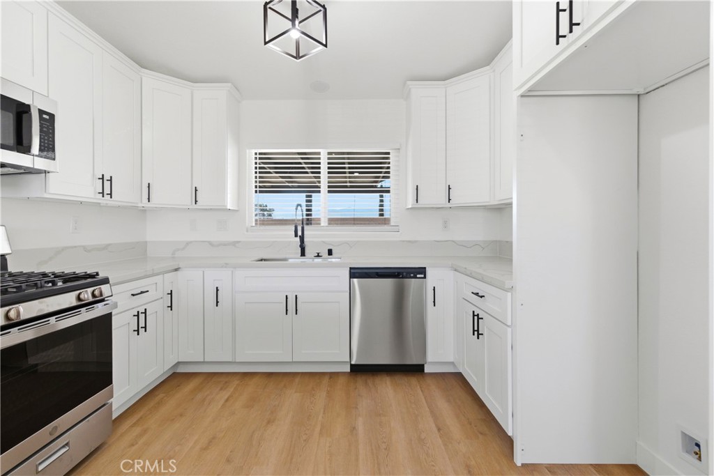 22557 Ojai Road Apple Valley, CA 92308 - Photo 9 of 57 a kitchen with granite countertop white cabinets and white appliances