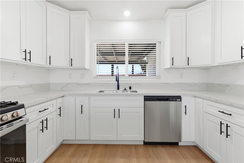 22557 Ojai Road Apple Valley, CA 92308 - Photo 10 of 57 a kitchen with white cabinets and sink