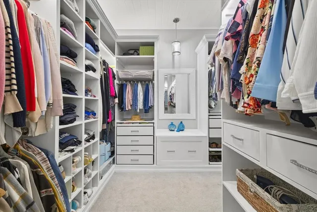 a view of walk in closet with clothes and shoes