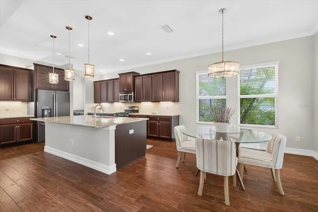 a kitchen with stainless steel appliances granite countertop wooden floors and white cabinets
