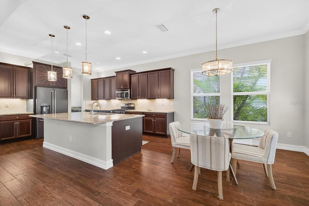 6609 Current Drive Apollo Beach, FL 33572 - Photo 9 of 47 a kitchen with stainless steel appliances granite countertop wooden floors and white cabinets