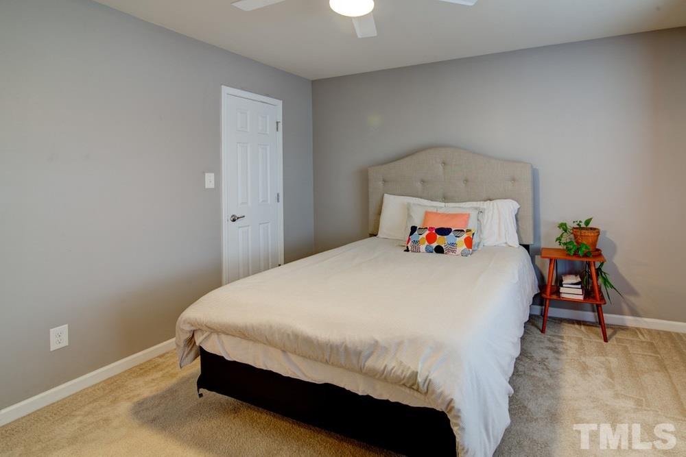 874 Seastone Street Raleigh, NC 27603 - Photo 22 of 30 a bedroom with a bed and a table in it