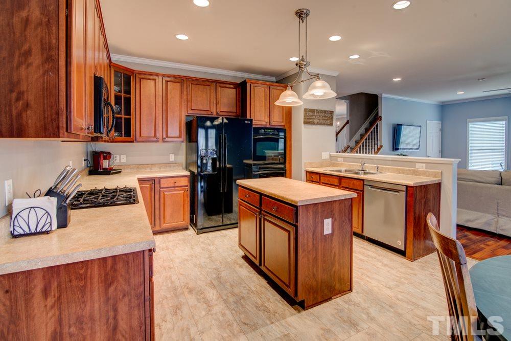 874 Seastone Street Raleigh, NC 27603 - Photo 4 of 30 a kitchen with stainless steel appliances granite countertop wooden cabinets a sink dishwasher and a stove