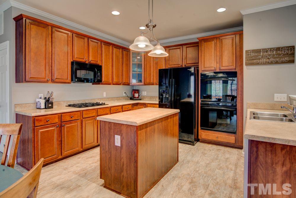874 Seastone Street Raleigh, NC 27603 - Photo 6 of 30 a kitchen with granite countertop stainless steel appliances a refrigerator stove top oven and large window