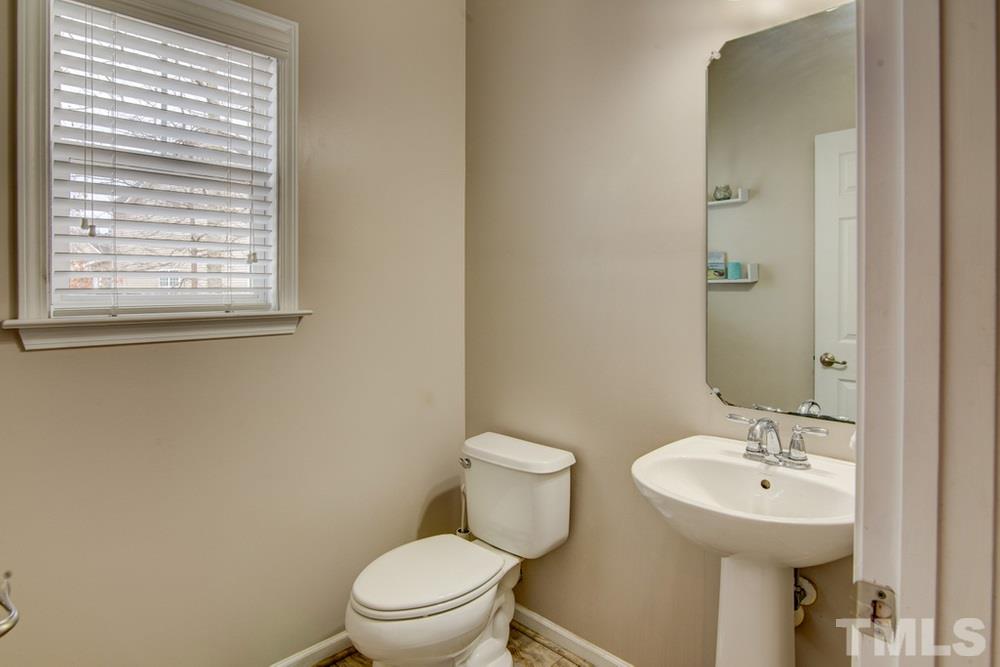 874 Seastone Street Raleigh, NC 27603 - Photo 10 of 30 a bathroom with a sink a toilet and a mirror