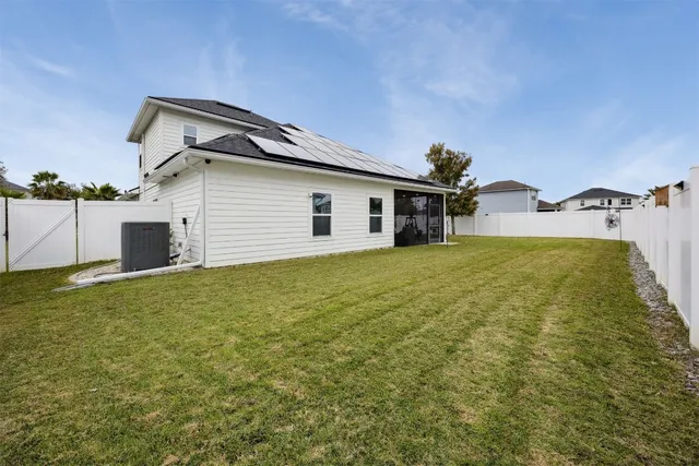an aerial view of residential houses with outdoor space and trees