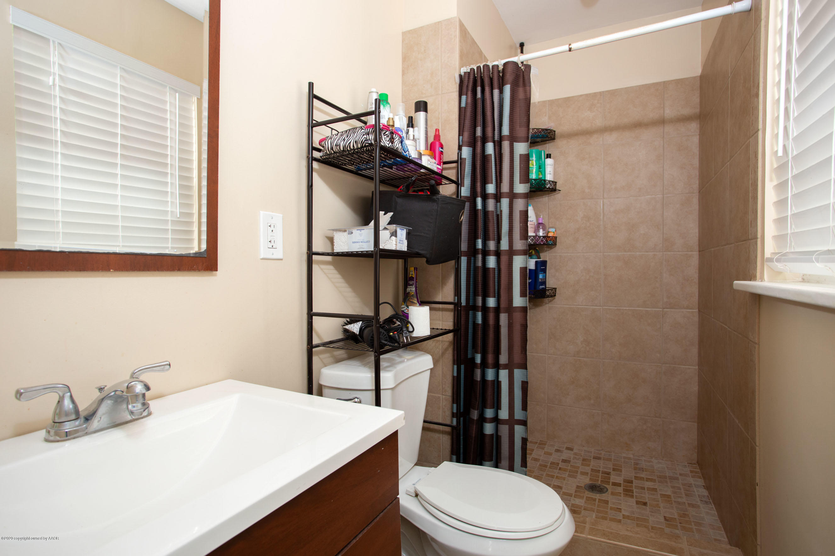 4712 South Milam Street Amarillo, TX 79110 - Photo 13 of 22 a bathroom with a sink a toilet and shower