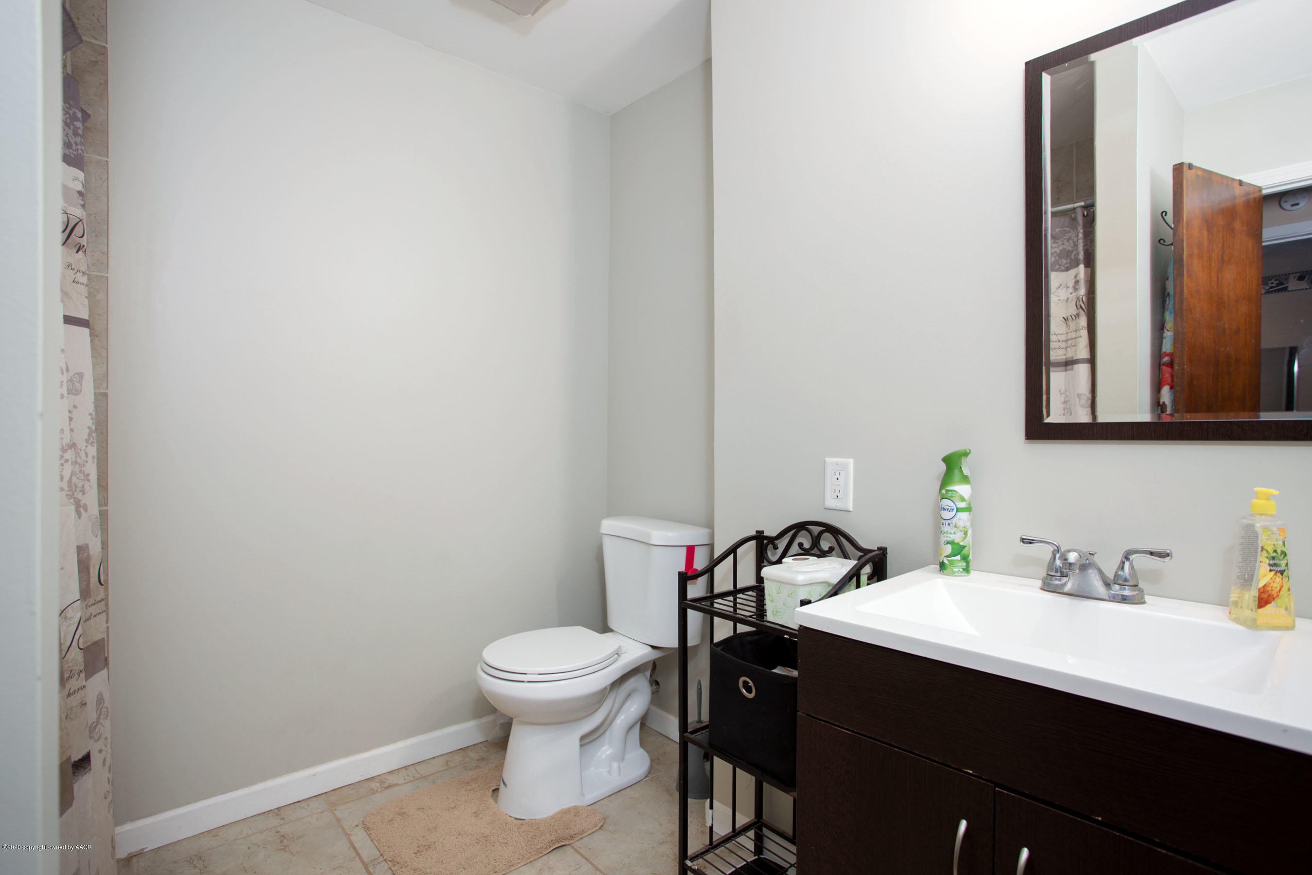 4712 South Milam Street Amarillo, TX 79110 - Photo 18 of 22 a bathroom with a toilet a sink and mirror