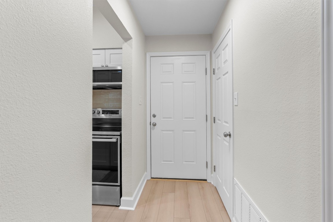 2215 Post Road, Unit 2051 Austin, TX 78704 - Photo 11 of 37 a view of empty room with wooden floor and kitchen