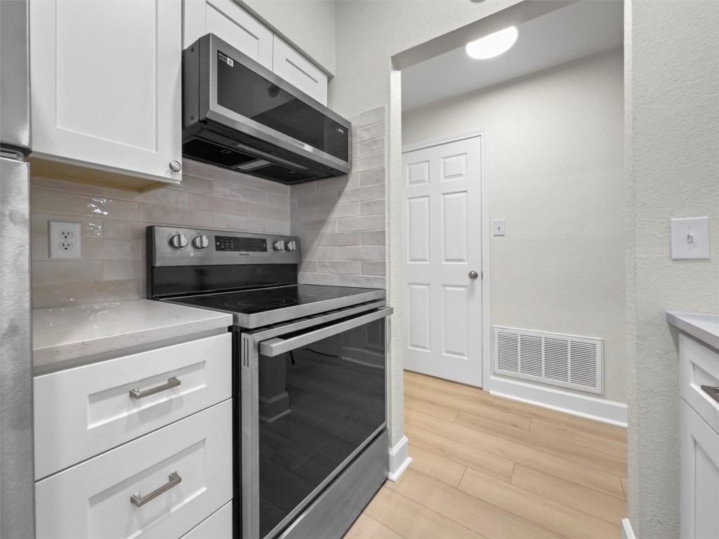 2215 Post Road, Unit 2051 Austin, TX 78704 - Photo 16 of 37 a kitchen with stainless steel appliances white cabinets and a stove