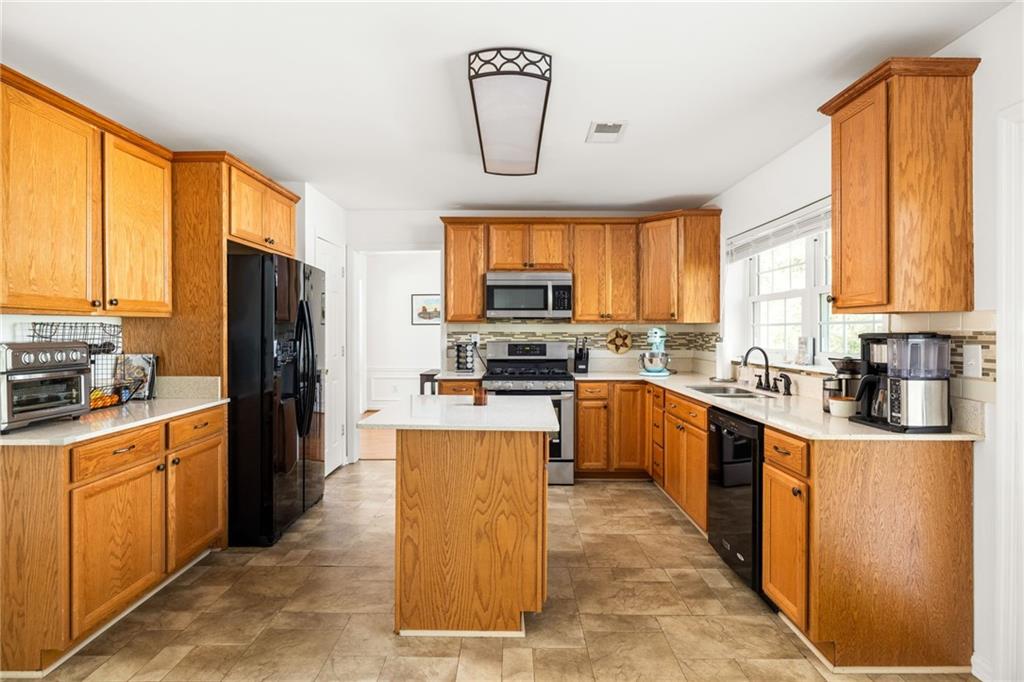 3384 Southern Oaks Court Decatur, GA 30034 - Photo 3 of 27 a kitchen with granite countertop wooden cabinets a stove top oven a sink and a refrigerator
