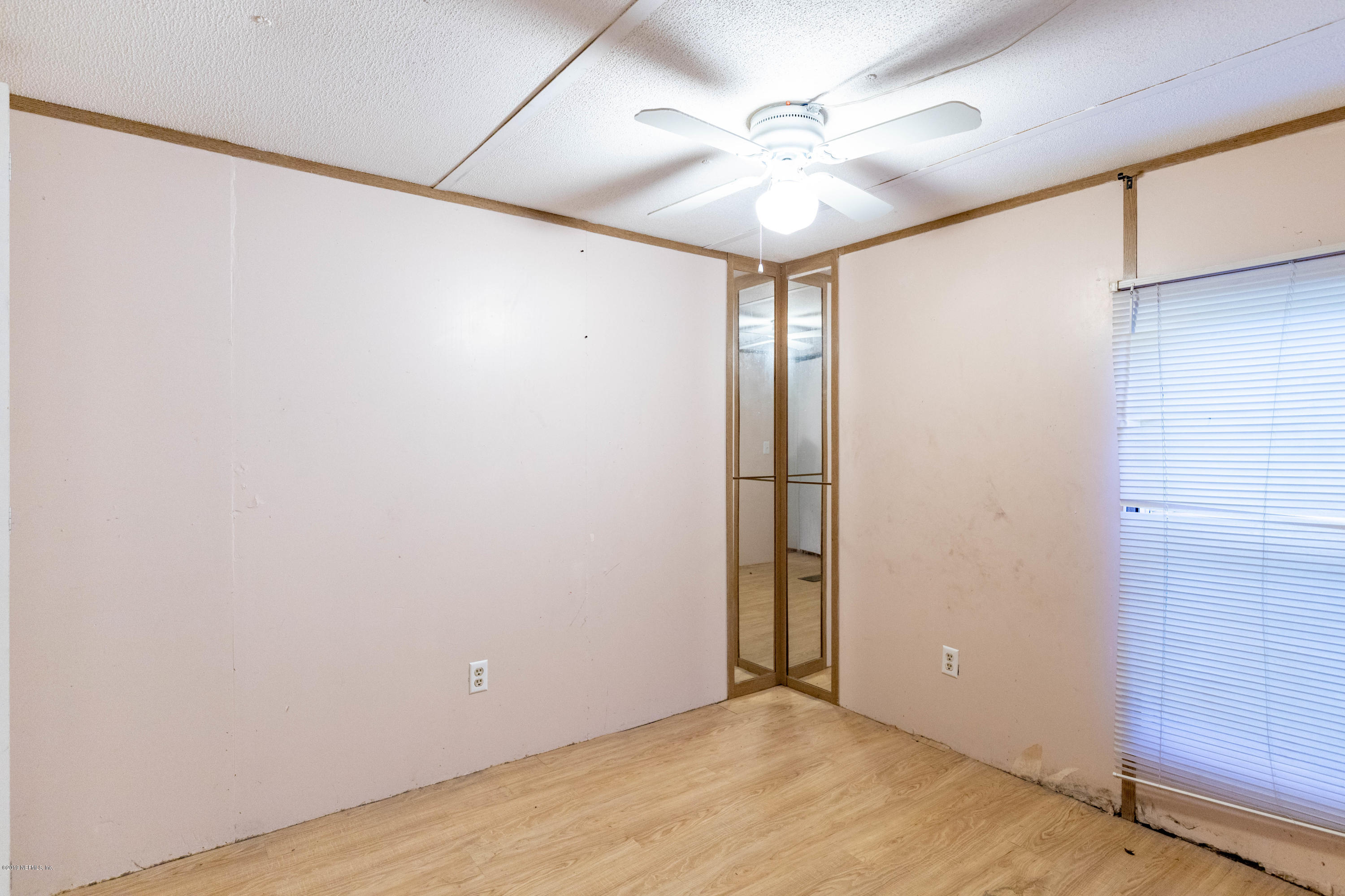 7840 Old Middleburg Road South Jacksonville, FL 32222 - Photo 21 of 46 an empty room with a chandelier fan and windows