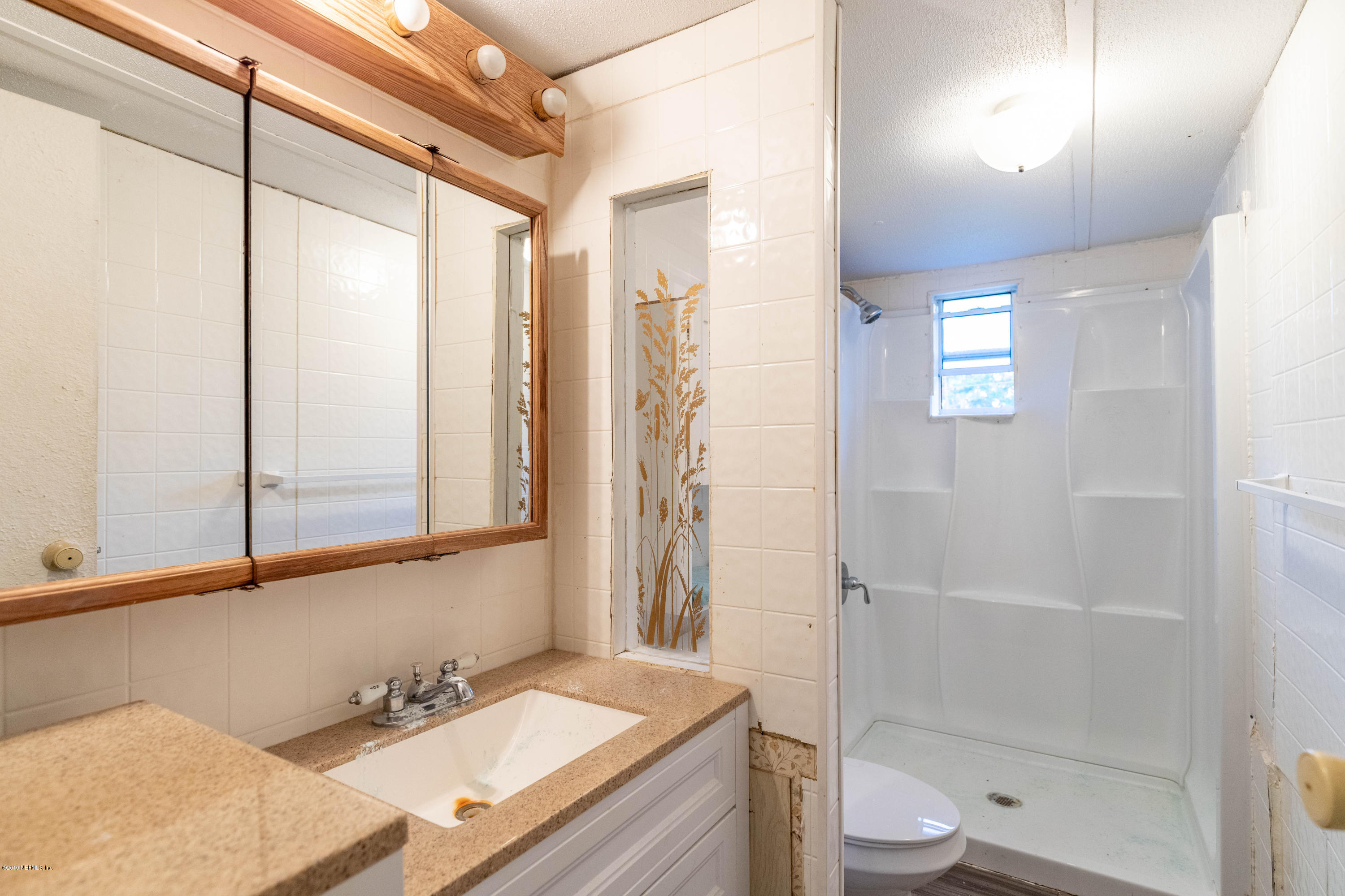 7840 Old Middleburg Road South Jacksonville, FL 32222 - Photo 28 of 46 a bathroom with a bathtub shower sink vanity and toilet