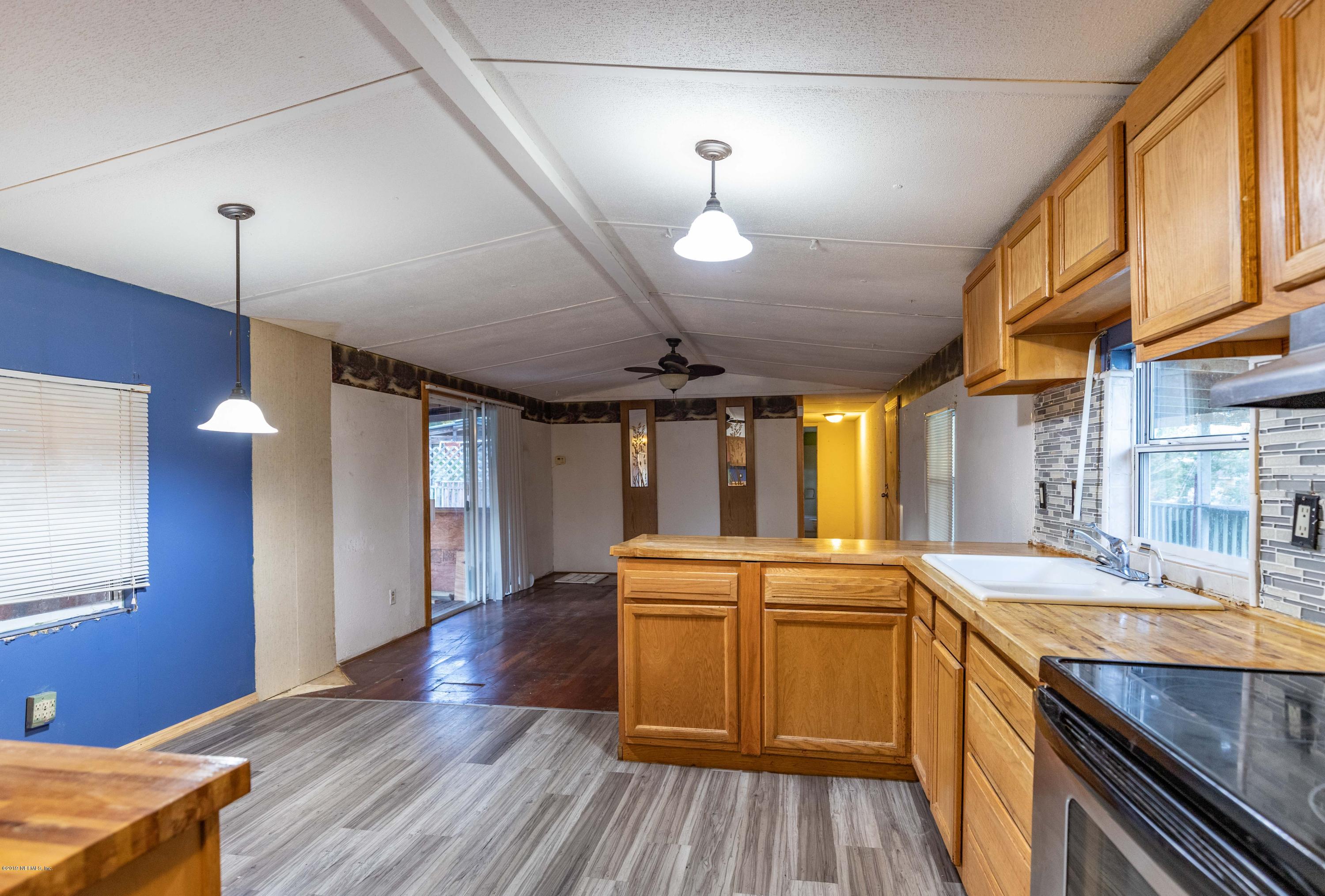 7840 Old Middleburg Road South Jacksonville, FL 32222 - Photo 32 of 46 a kitchen with a sink stove and wooden floor