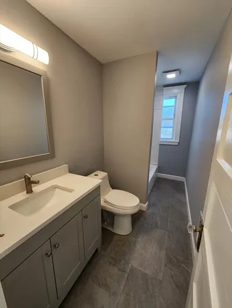 a bathroom with a toilet sink and mirror