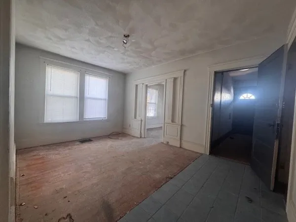a view of an empty room with window and closet area