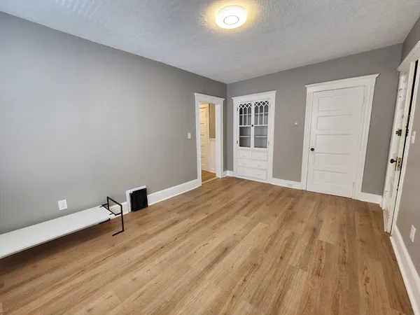 an empty room with wooden floor and windows