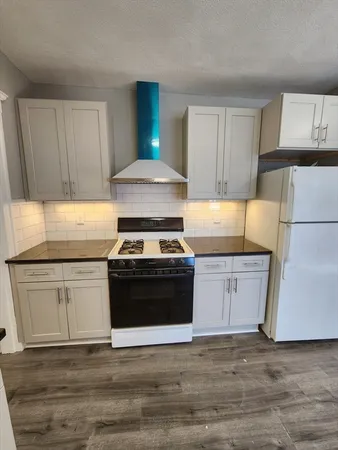 a kitchen with a stove and white cabinets