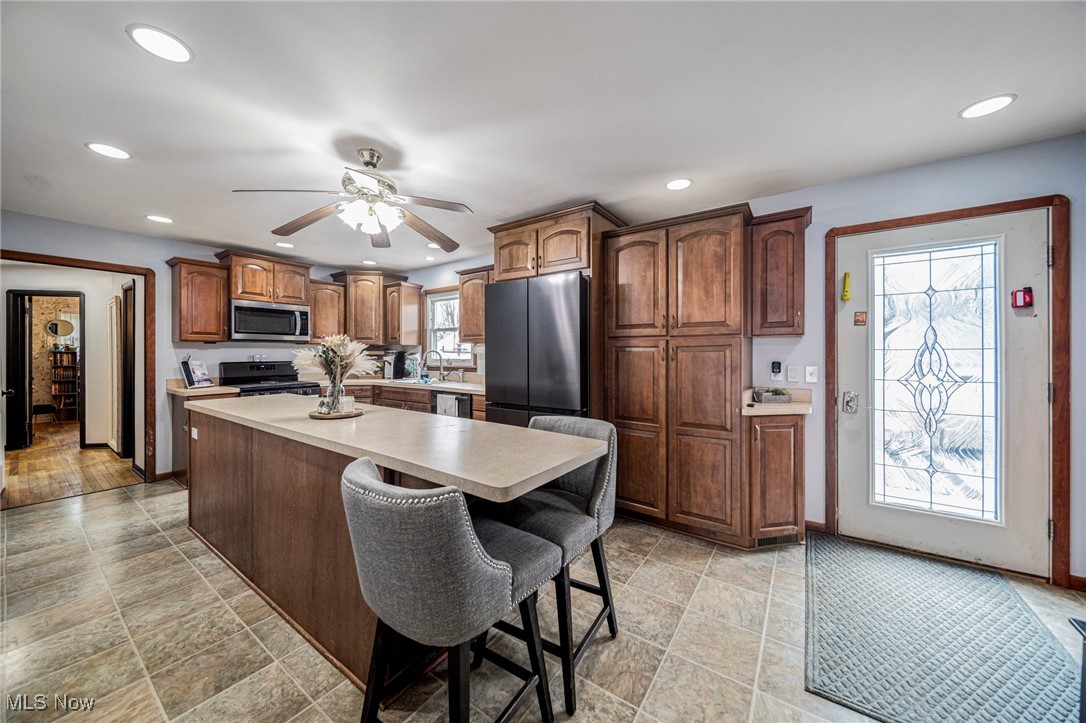 6600 Reynolds Road Mentor, OH 44060 - Photo 11 of 35 Kitchen featuring sink, a breakfast bar area, a kitchen island, ceiling fan, and stainless steel appliances